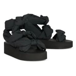 Moderne sort sandal med plateau og omsluttende rem.